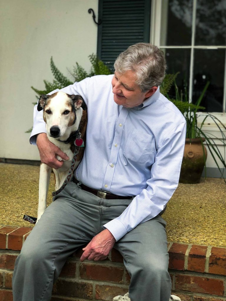 John Kennedy sitting with his dog outside, promoting his Senate campaign.